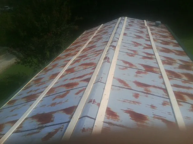 Rusted metal roof panels with new wood purlins before replacement — Storm Damage Roof Repair in Herminie by Roofing Brothers