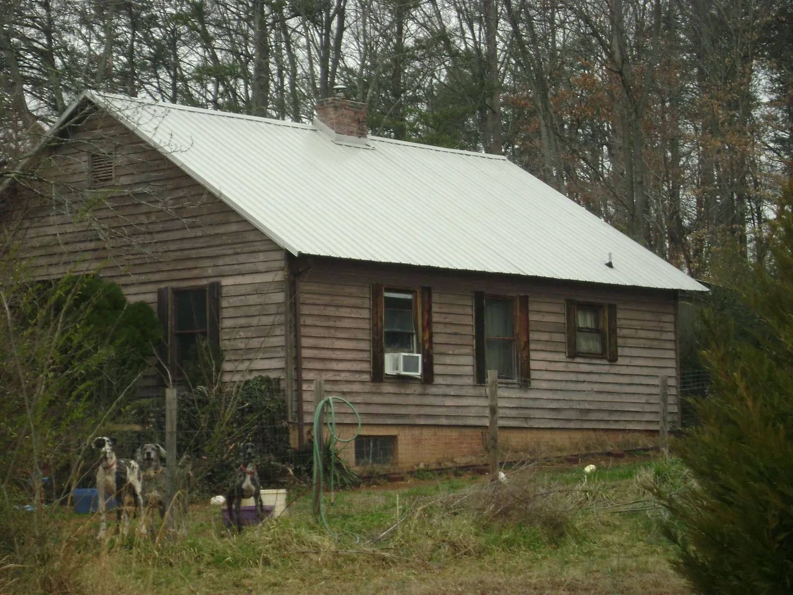 White metal roof on an old wood sided farmhouse, from a Metal Roof Installation job in Herminie